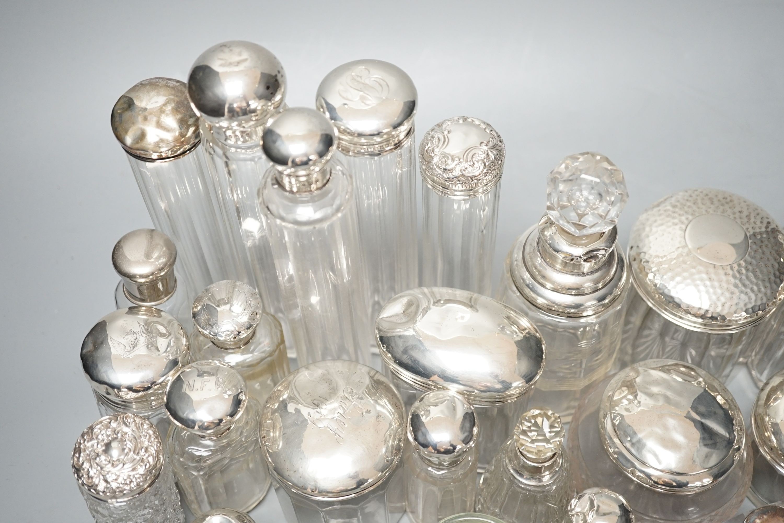 A collection of assorted mainly silver-capped scent bottles and toilet bottles.